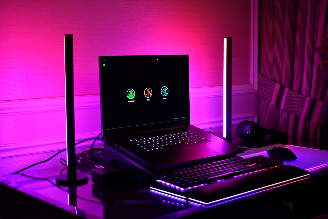 Gaming setup with laptop, keyboard, and rgb lighting.